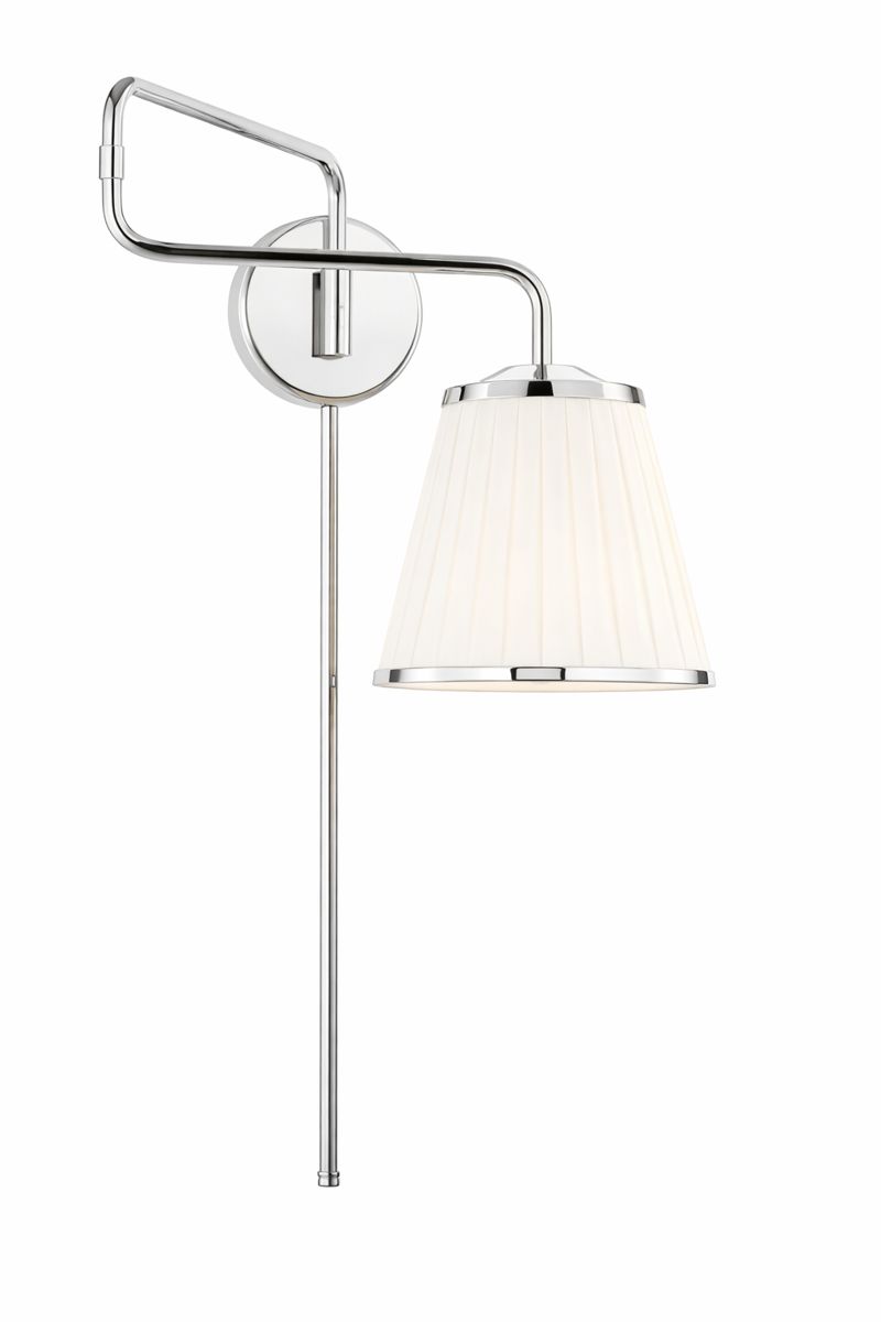 Decorative table lamp with a brass base and intricate floral patterns, illuminated with a warm light, placed on a wooden surface in a cozy indoor setting